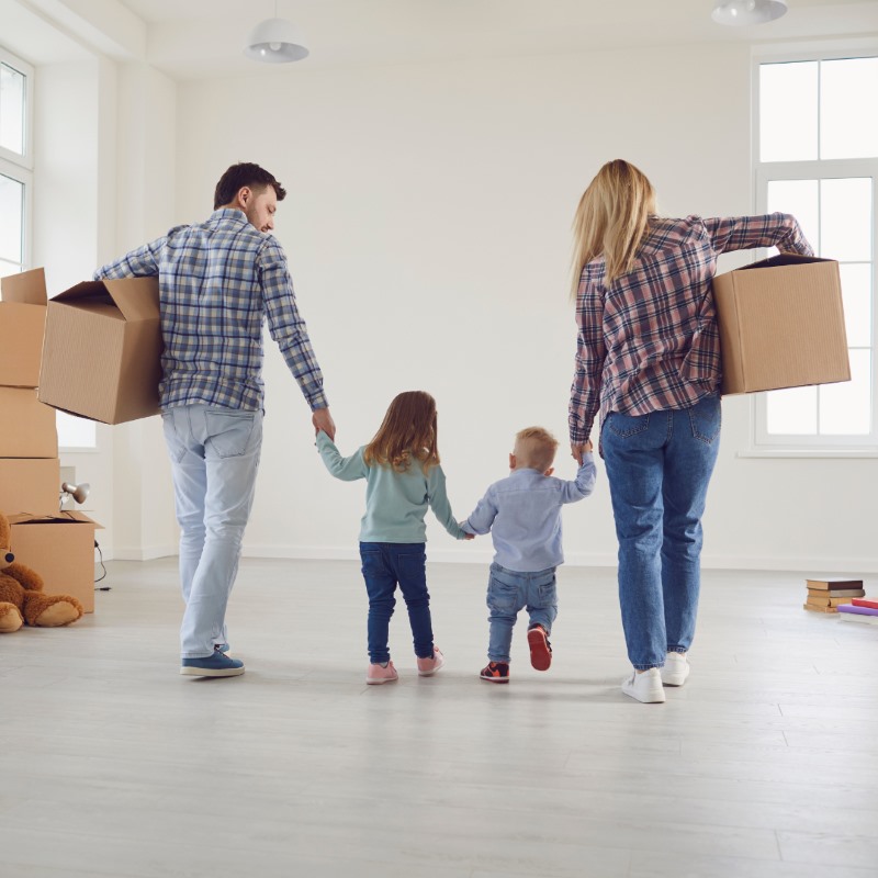 A family moving boxes out of their house into storage